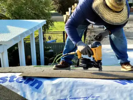 Roofer nailing shingles on residential roof replacement by J&V Builders