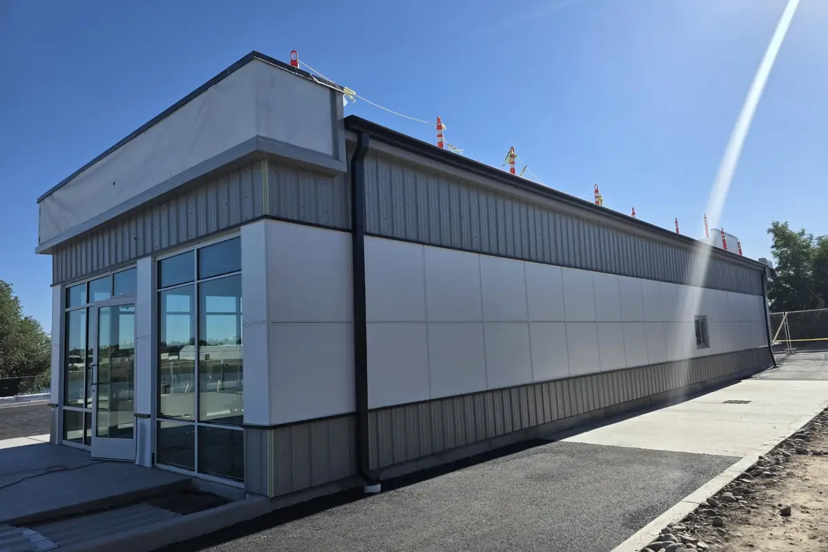 J&V Builders commercial building with storefront glass, white wall panels, and metal siding